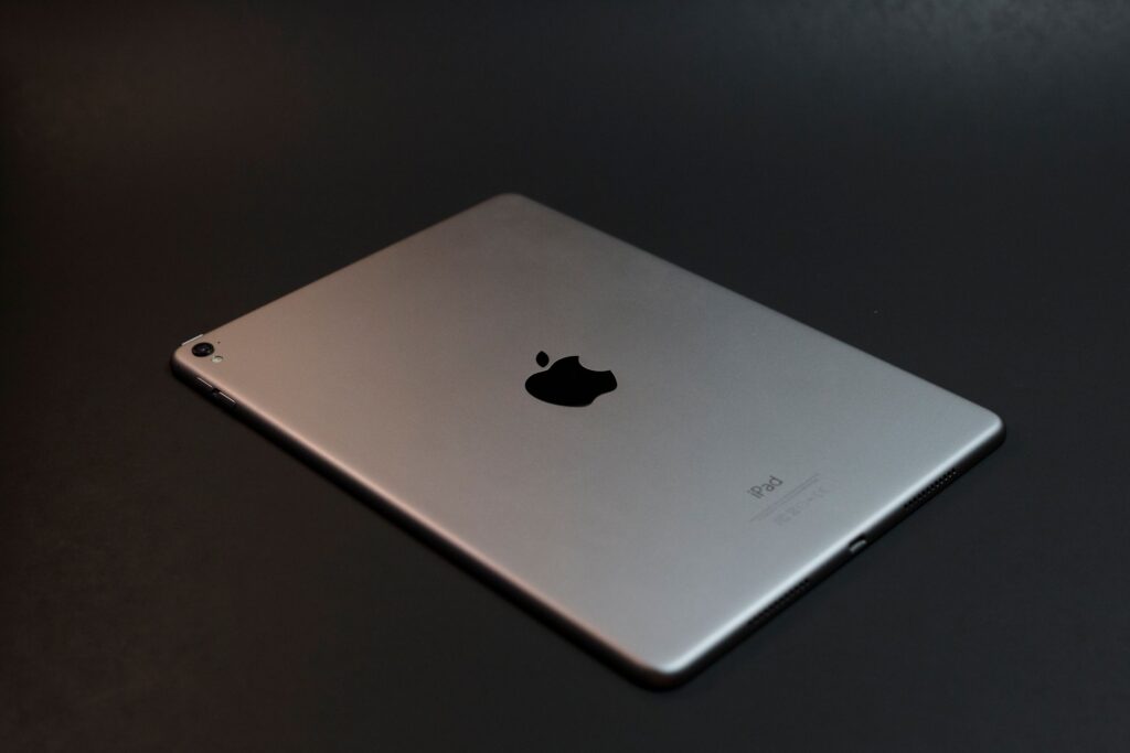 現在の画像: A modern silver tablet with a sleek design on a dark surface, showcasing advanced technology.