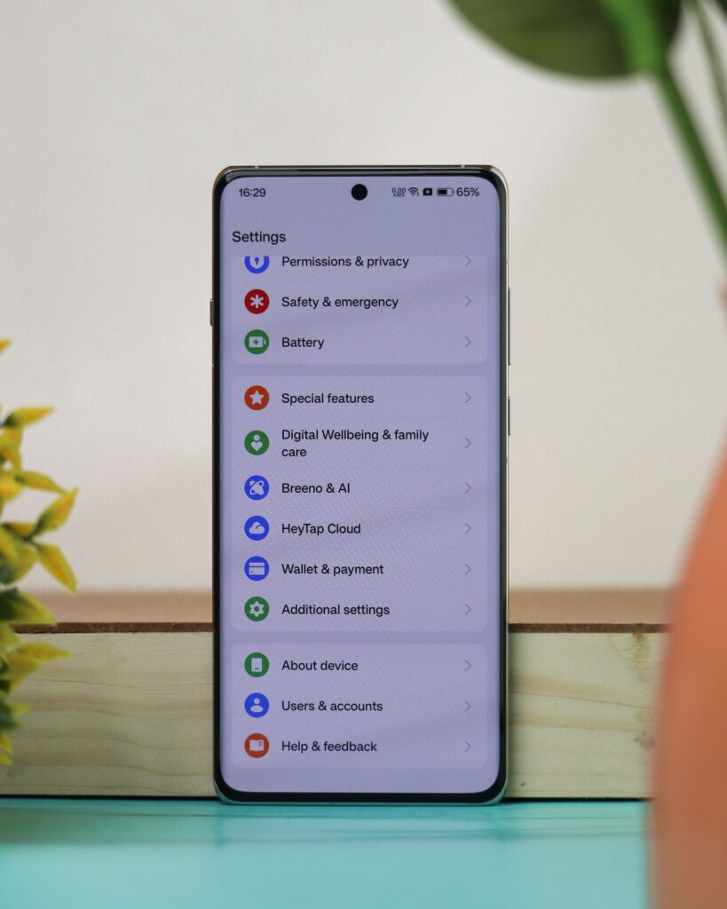 現在の画像: A smartphone on a desk with a settings screen, showcasing various menu options in an office setting.