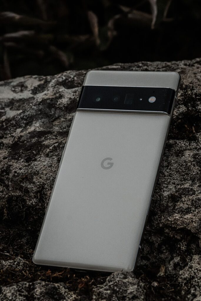 現在の画像: Close-up of a sleek camera phone on textured stone, showcasing modern design.