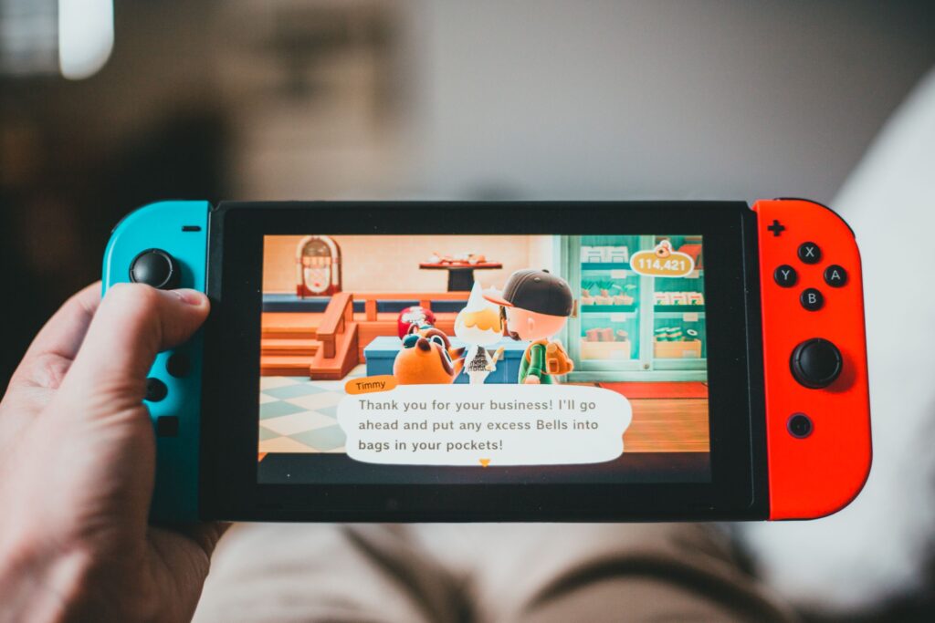 現在の画像: Crop anonymous person playing videogame while using game console and sitting at home on blurred background